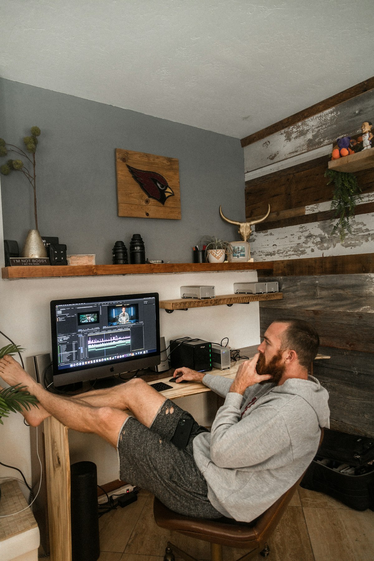 Person reclining in a desk chair with bare feet propped up at desk height, showing a relaxed ankle position rather than a fixed right angle