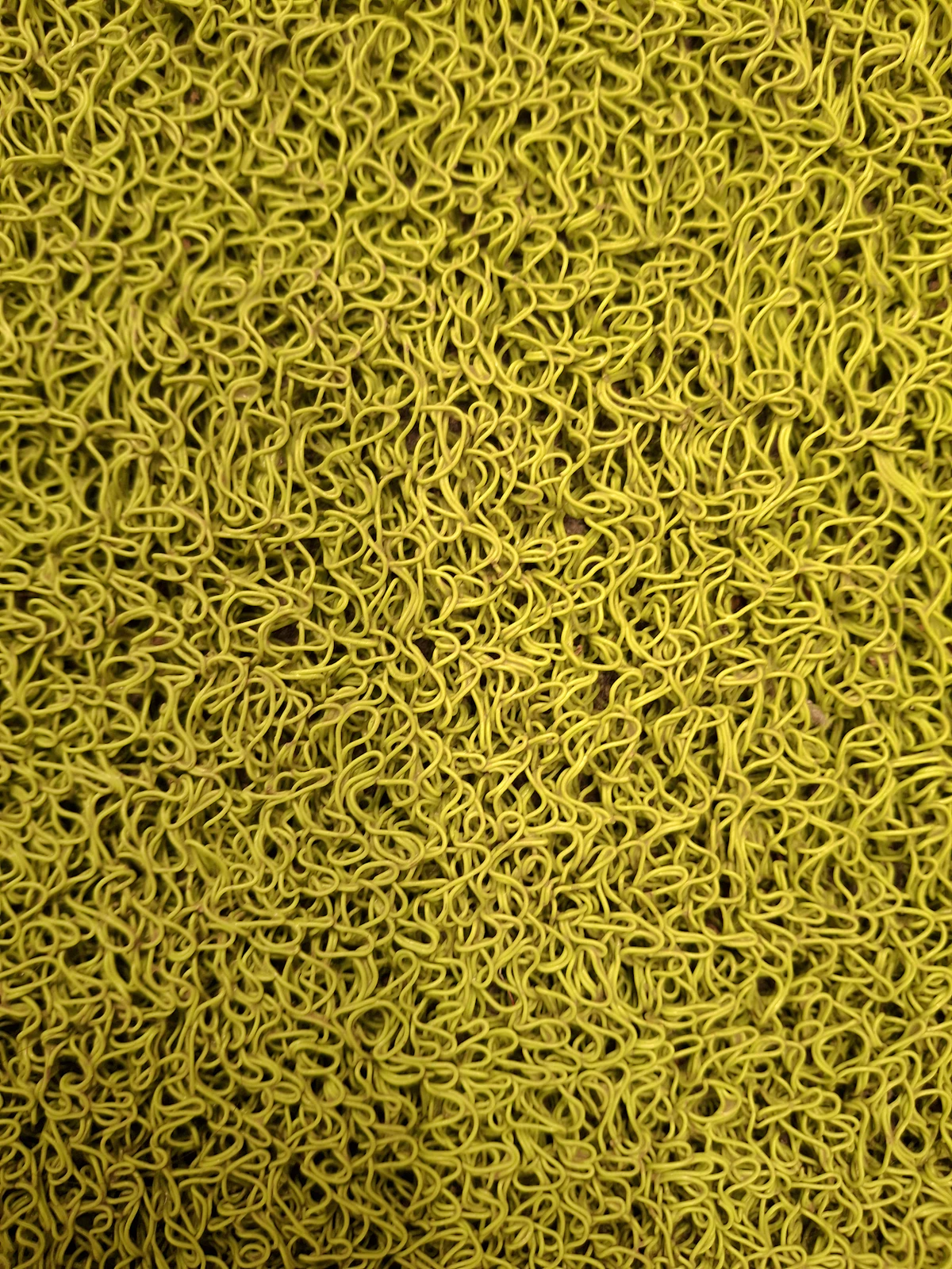 Close-up of a textured yellow rubber anti-fatigue floor mat surface