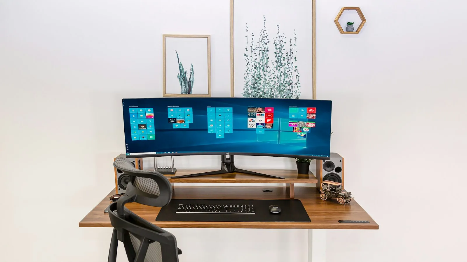 Wood-toned standing desk with a monitor and keyboard in a bright home office