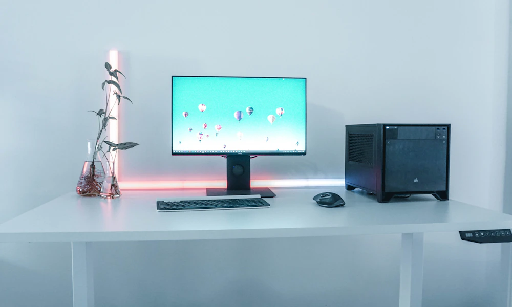 Minimalist desk with a monitor, keyboard, and mouse arranged for a clean, organized sit-stand workspace