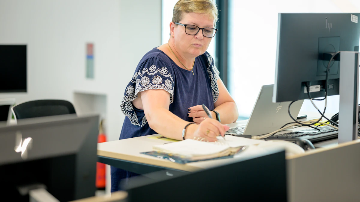 Person working standing up at an adjustable desk with a laptop, the kind of setup a desk converter creates on top of an existing desk