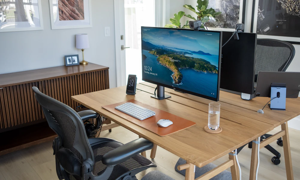 Wooden desk with a computer monitor and keyboard, the kind of setup to check against a desk converter weight rating