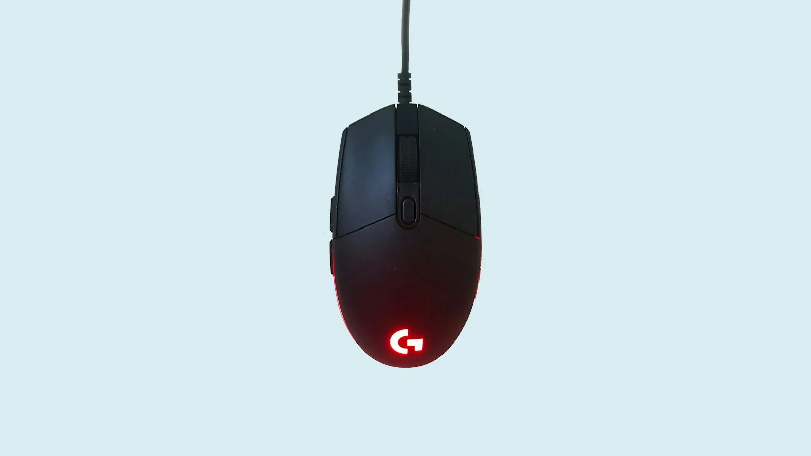 Black and red corded gaming mouse on a desk, representing the ergonomic gaming mouse side of the comparison