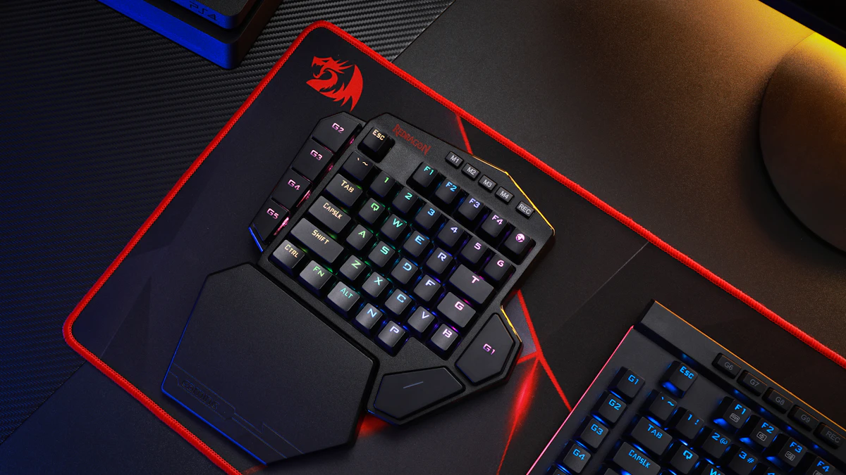 Black and red mechanical gaming keyboard on a desk, the kind of setup that needs extra tray width for a large mousepad