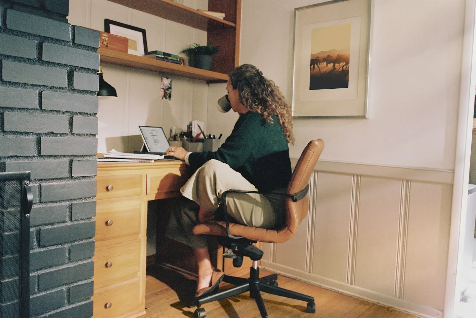 Woman working at a desk with a coffee cup, the kind of long seated stretch where a seat cushion choice starts to matter