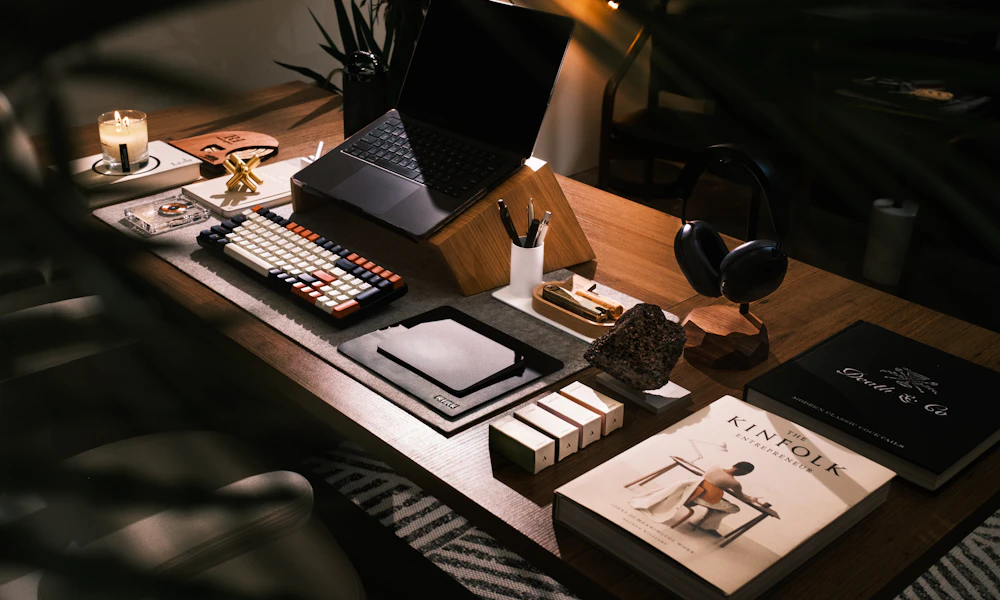 Modern desk setup with a laptop next to a stack of books, illustrating the free book-stack alternative to a laptop stand