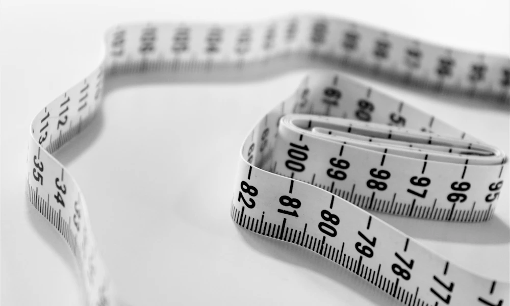 Close-up of a tape measure, the tool needed to check desk depth before buying a standing desk converter