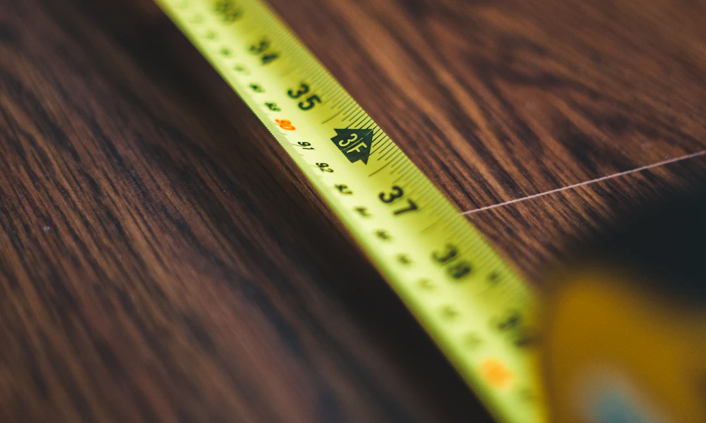 Keyboard Tray Knee Clearance: How to Measure Before You Buy 2 Coiled measuring tape on a wooden surface, the tool needed to check keyboard tray knee clearance before buying