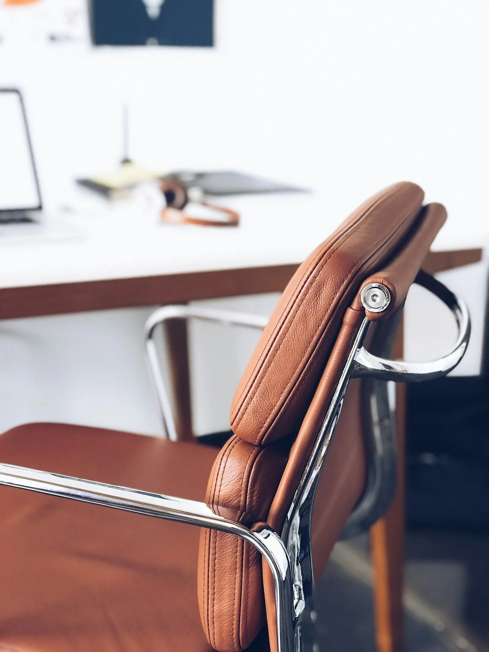Memory Foam vs Inflatable Lumbar Cushion: Which Is Better? 2 Close-up of a brown leather office chair back, showing the curve where a lumbar cushion would sit