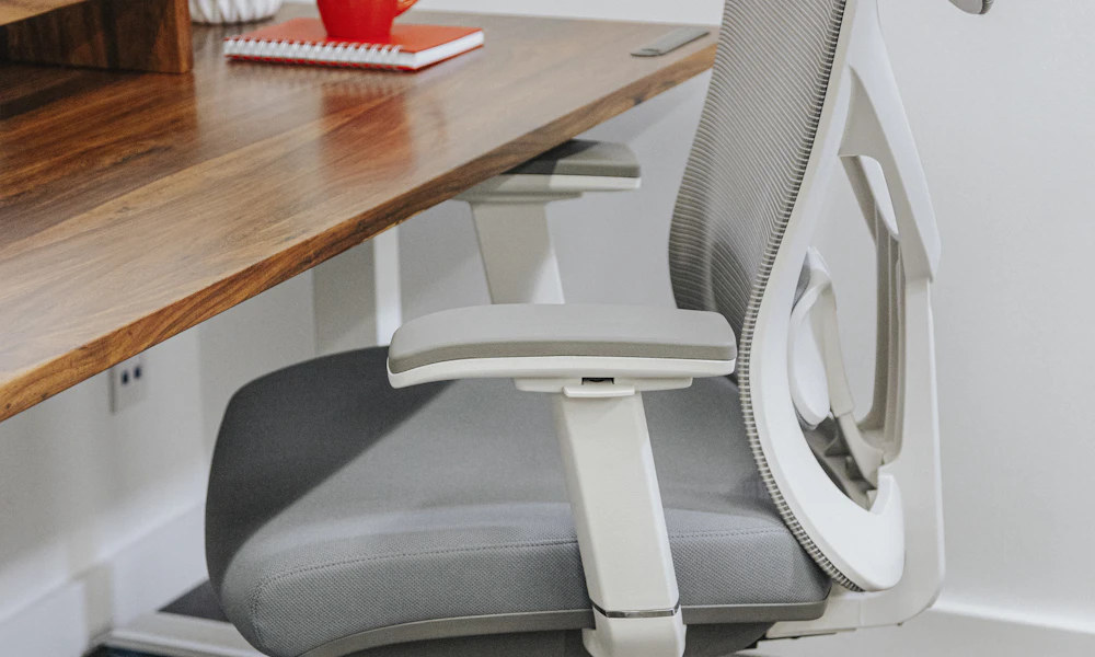 Ergonomic office chair positioned at a wooden desk in a home office setup