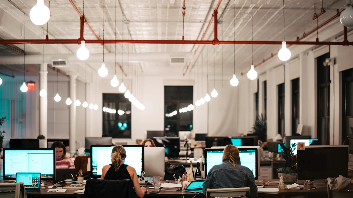 People sitting at desks in an office, a mix of chair types and body sizes typical of a shared workspace
