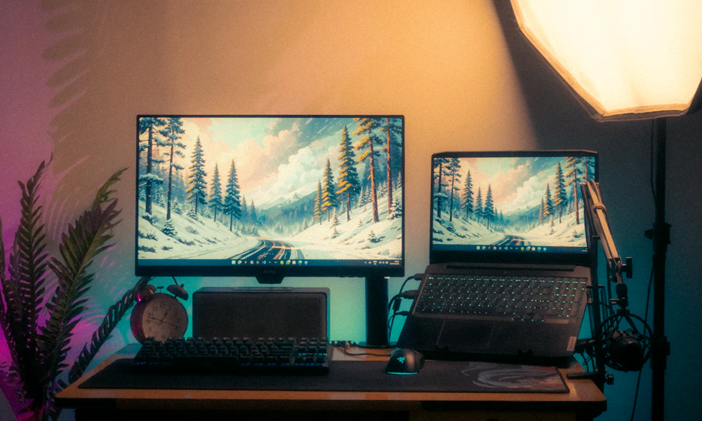 Modern desk setup with two monitor screens side by side, a dual monitor arm workspace