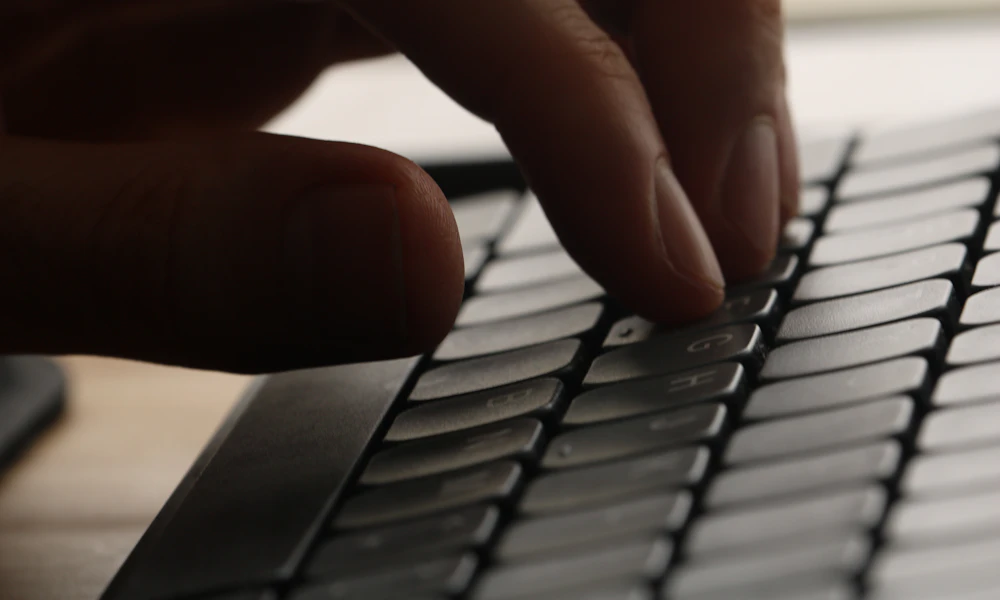 Close-up of a hand typing on a computer keyboard