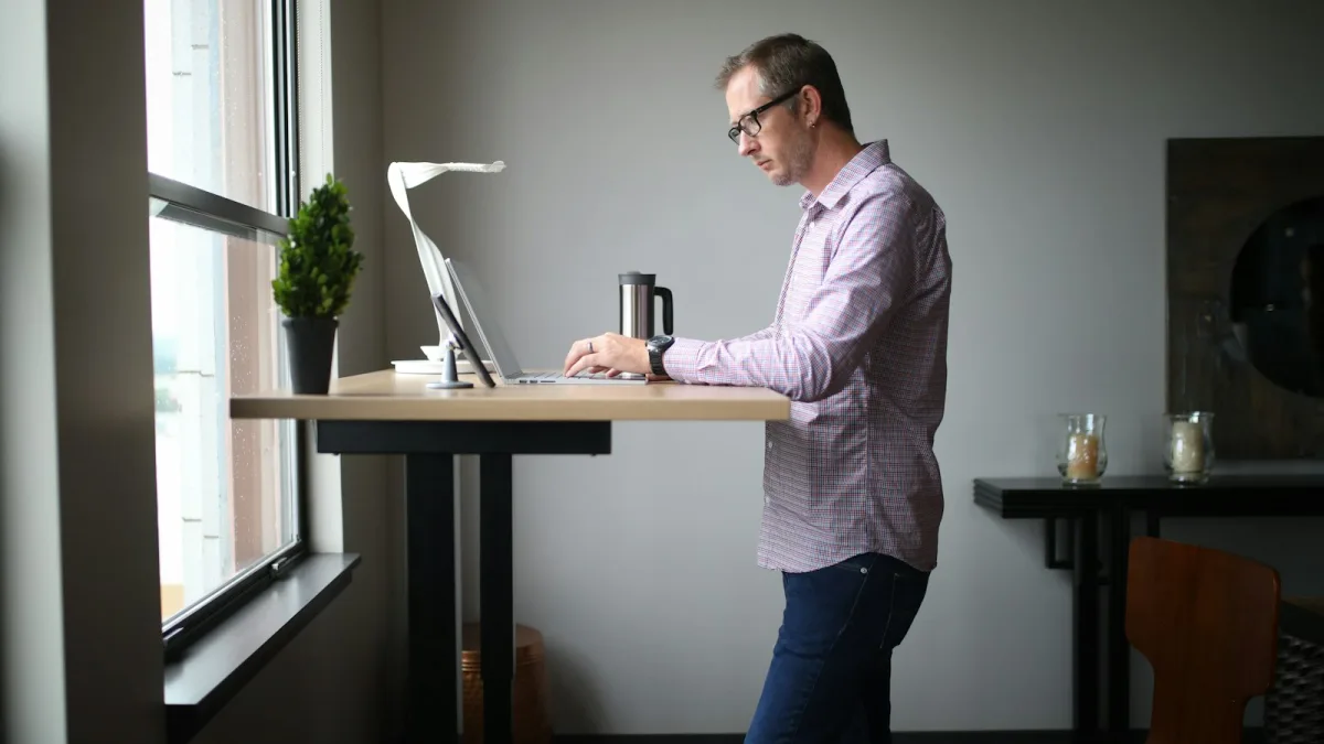 What Is a Standing Desk Memory Preset, and Do You Need One? 1 Man standing at a wooden standing desk working in a home office