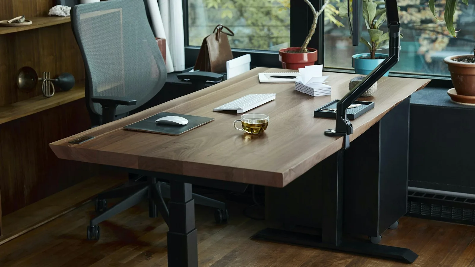How Fast Should a Standing Desk Raise and Lower? 1 Electric standing desk in a wooden home office setup, raised to standing height