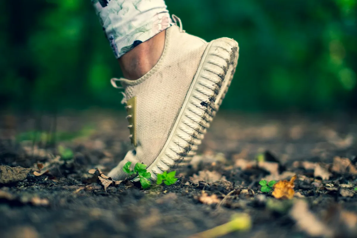 Close-up of a person wearing cushioned, supportive sneakers, the kind of footwear that already absorbs some standing impact